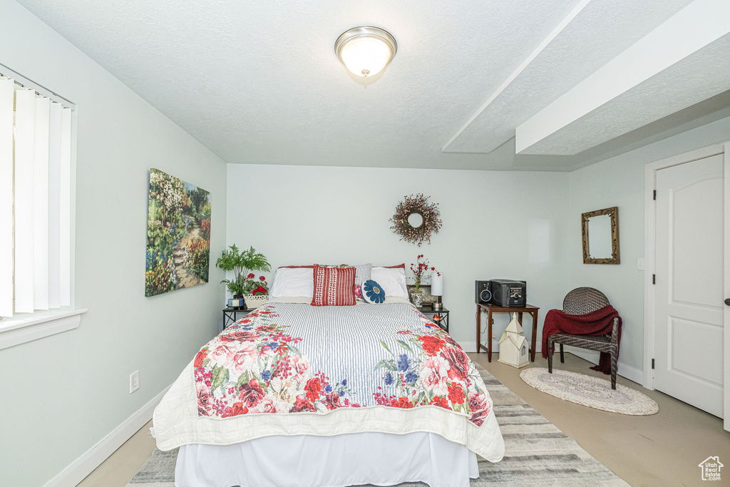 Bedroom featuring baseboards and a textured ceiling