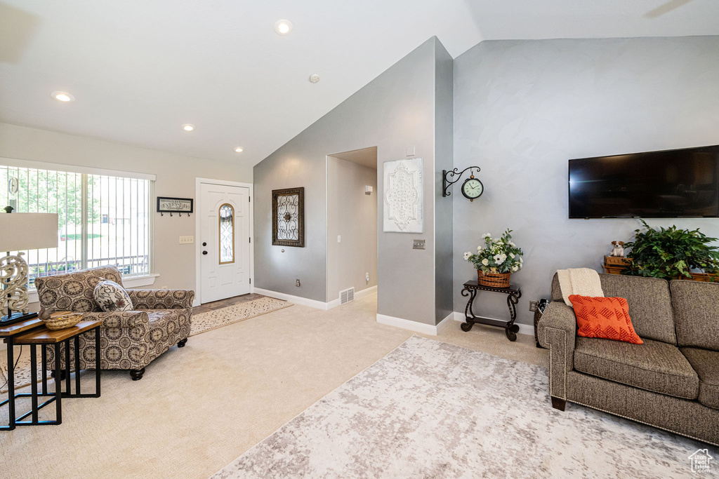 Living area featuring light colored carpet, baseboards, recessed lighting, and high vaulted ceiling
