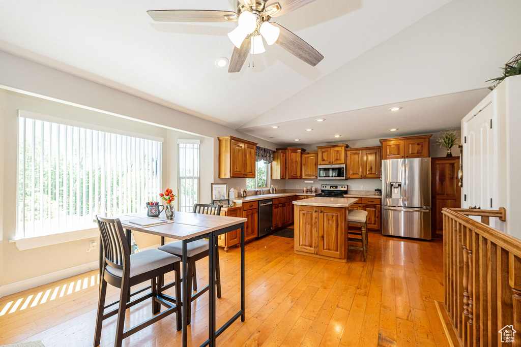 Dining room with light wood-style floors, recessed lighting, ceiling fan, and high vaulted ceiling