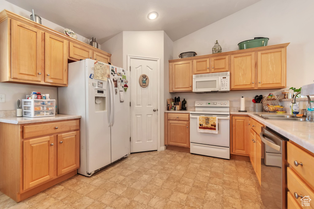 Kitchen featuring white appliances, a sink, light countertops, recessed lighting, and light brown cabinets