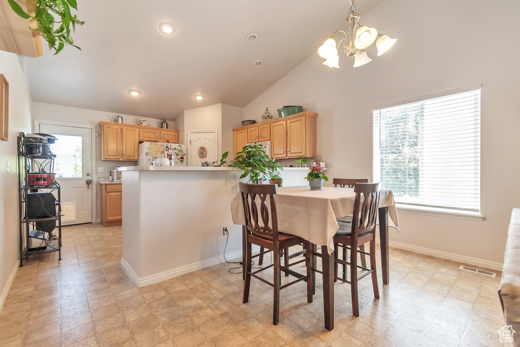 Dining area featuring a chandelier, vaulted ceiling, baseboards, and recessed lighting