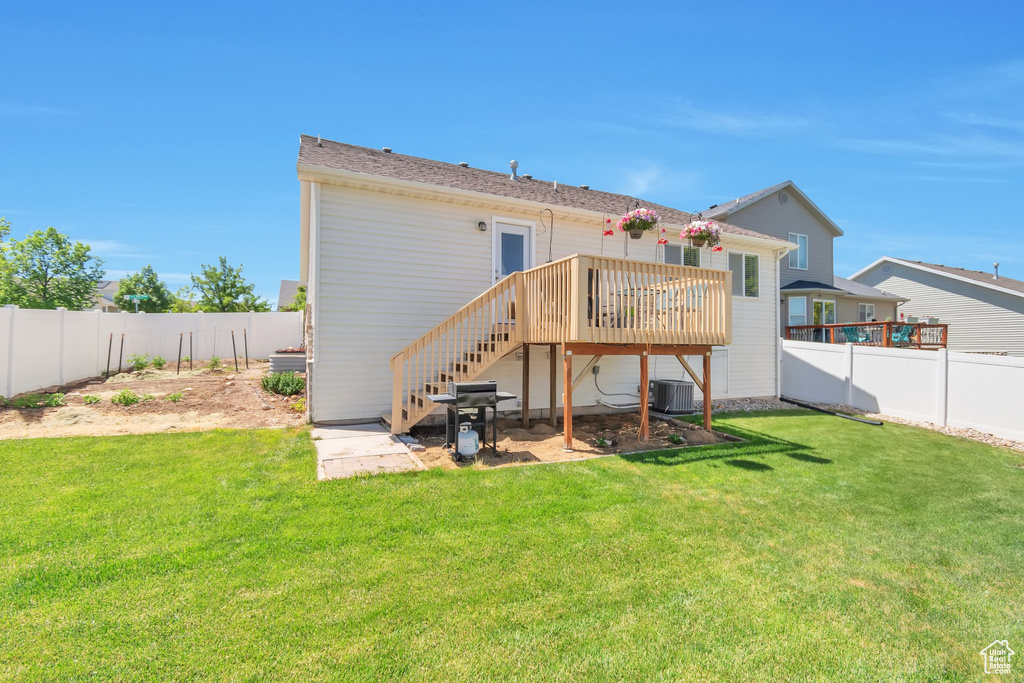 Back of house featuring a wooden deck, stairway, and central AC
