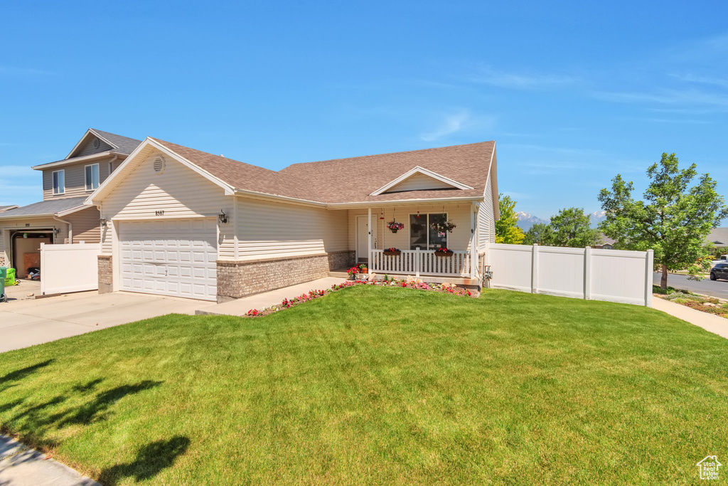 View of front of property featuring brick siding, a porch, an attached garage, driveway, and a shingled roof