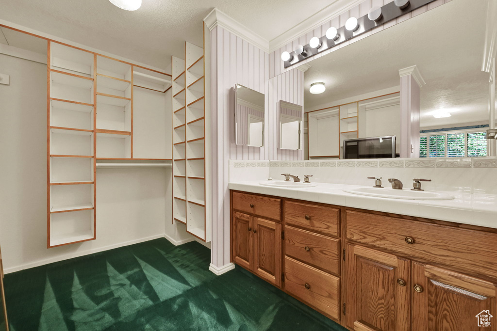Full bathroom with double vanity and baseboards