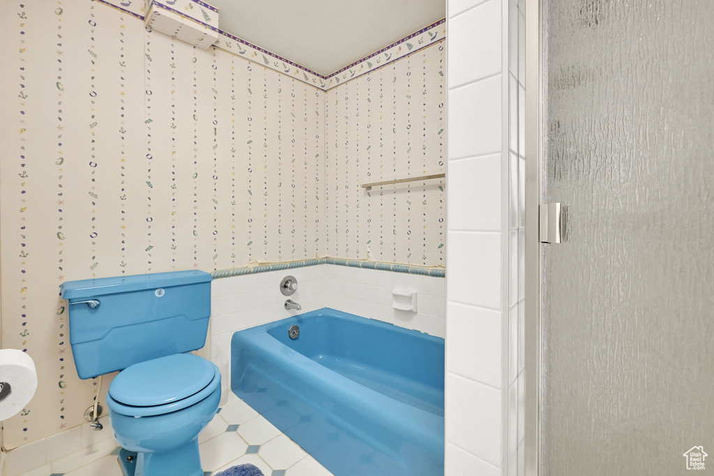 Bathroom featuring toilet, a bath, and tile patterned flooring