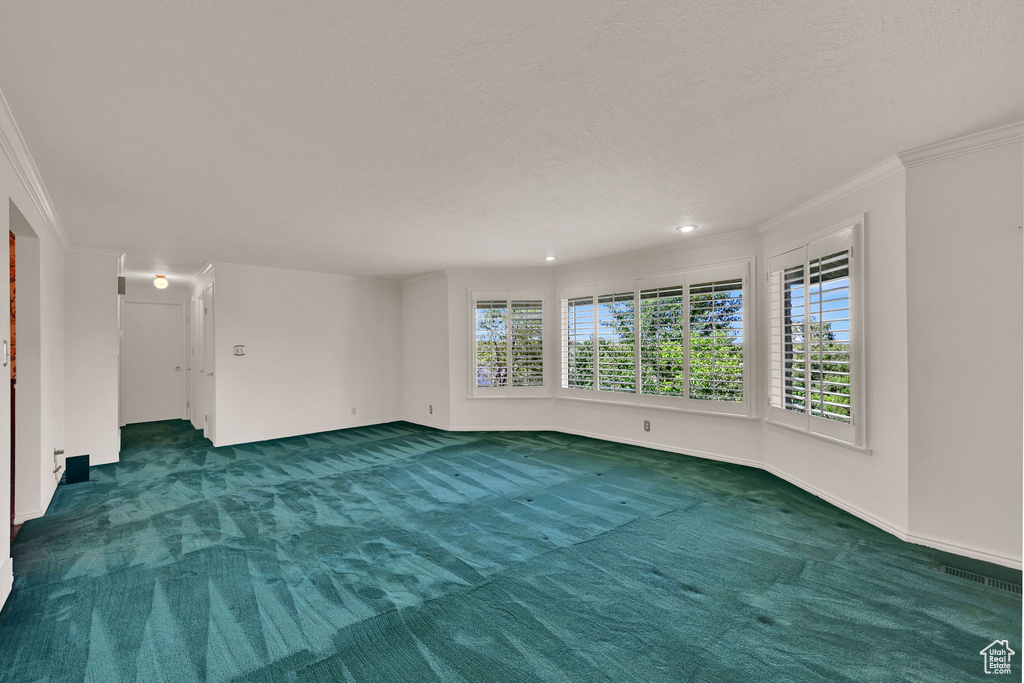 Empty room featuring ornamental molding, carpet flooring, a textured ceiling, recessed lighting, and baseboards