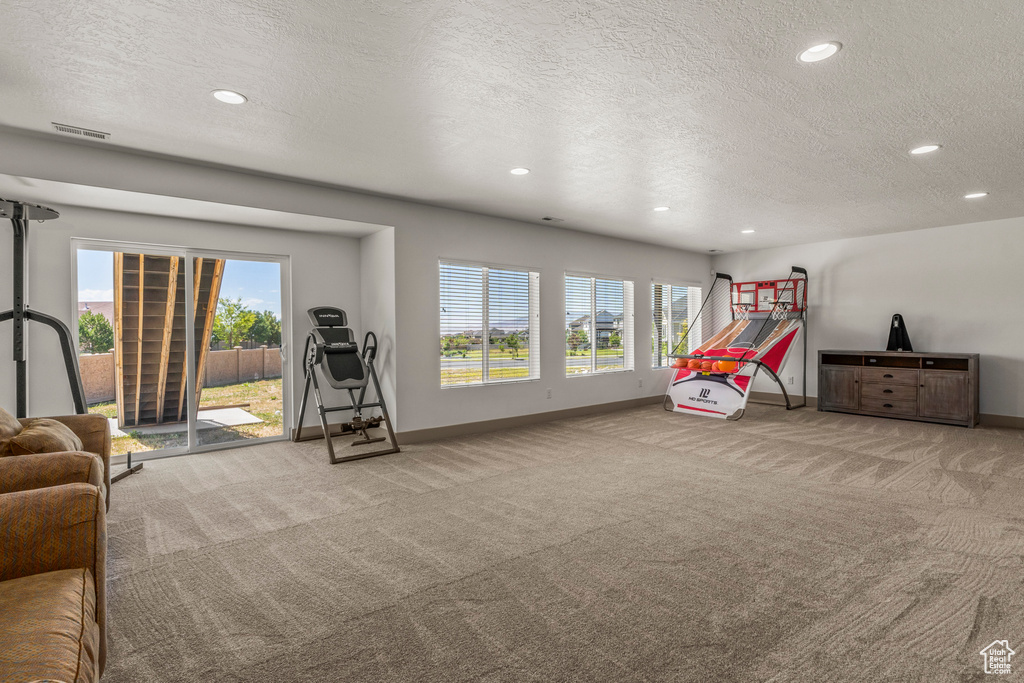 Game room with carpet, baseboards, a textured ceiling, recessed lighting, and healthy amount of natural light
