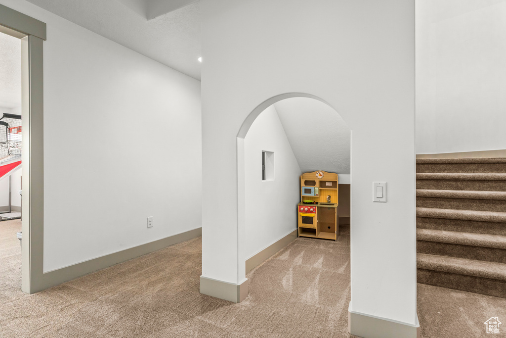Stairway with carpet, arched walkways, and baseboards