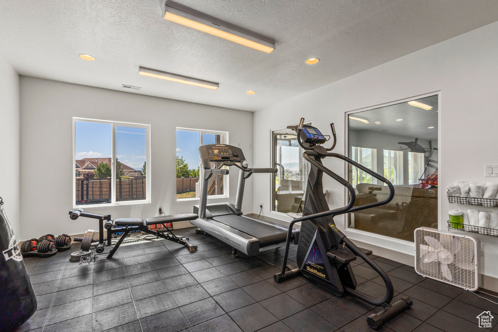 Exercise room with a textured ceiling and recessed lighting