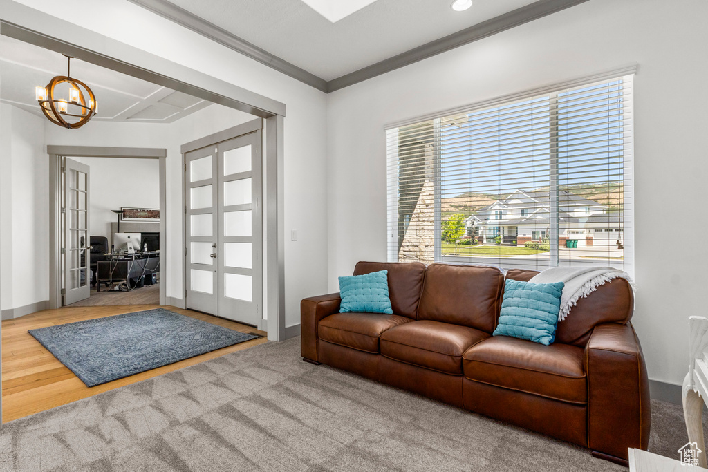 Living area with french doors, a chandelier, crown molding, baseboards, and recessed lighting