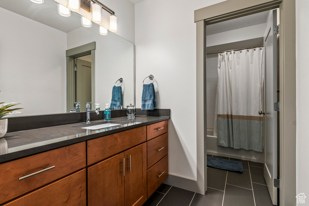 Bathroom featuring tile patterned flooring, vanity, and shower / bath combo