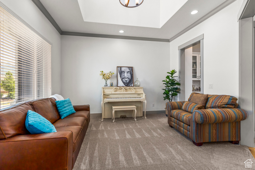 Carpeted living area with recessed lighting, a raised ceiling, and ornamental molding