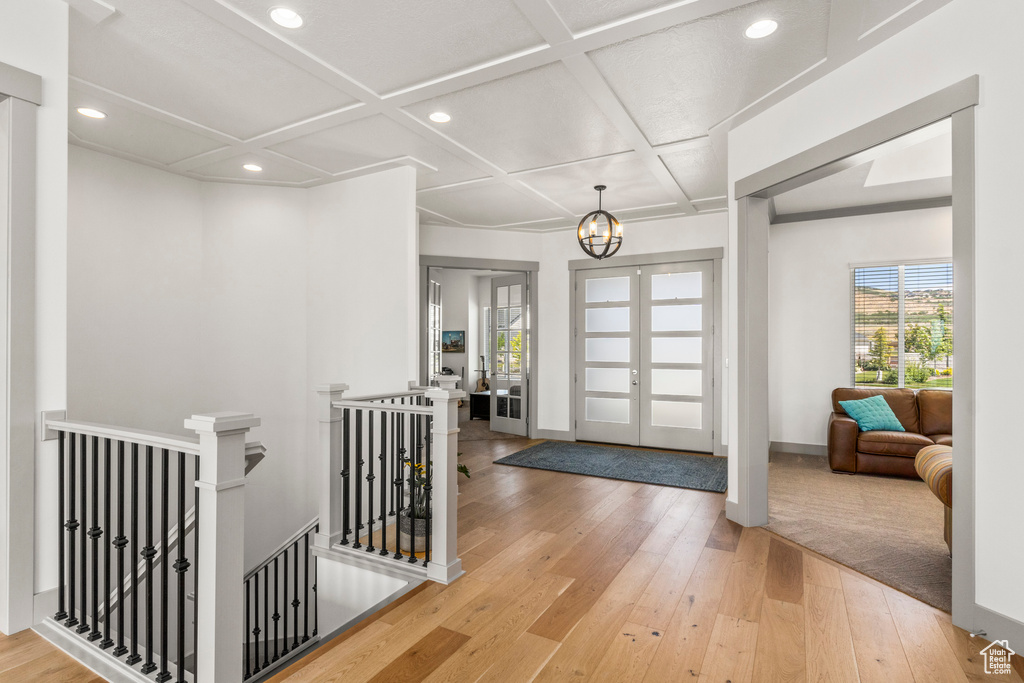 Foyer featuring coffered ceiling, wood-type flooring, recessed lighting, a chandelier, and baseboards