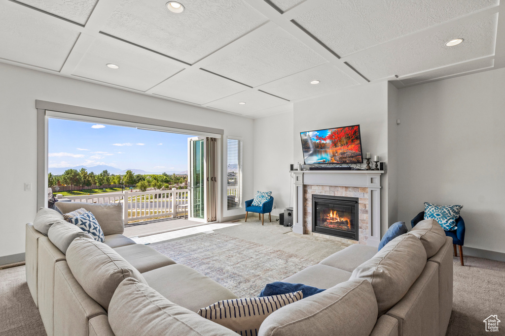 Carpeted living area featuring coffered ceiling, recessed lighting, a fireplace with flush hearth, and baseboards