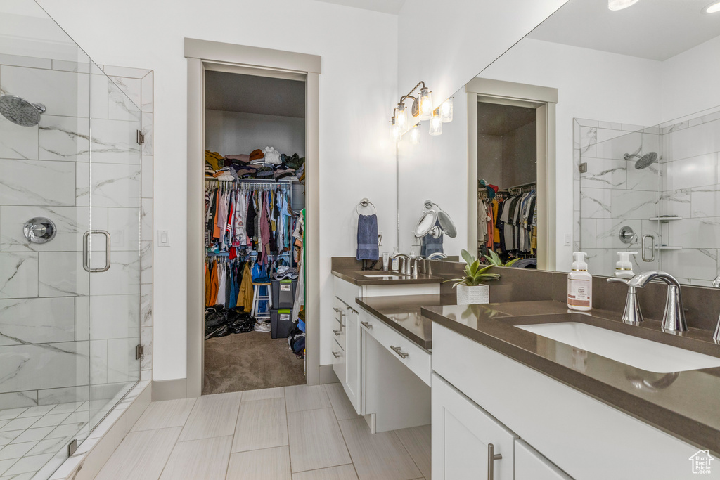 Full bath with vanity, a spacious closet, and a stall shower