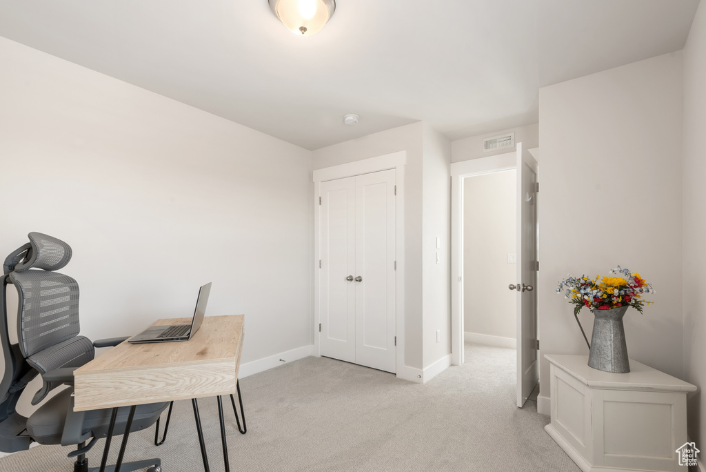 Office area with baseboards and light carpet