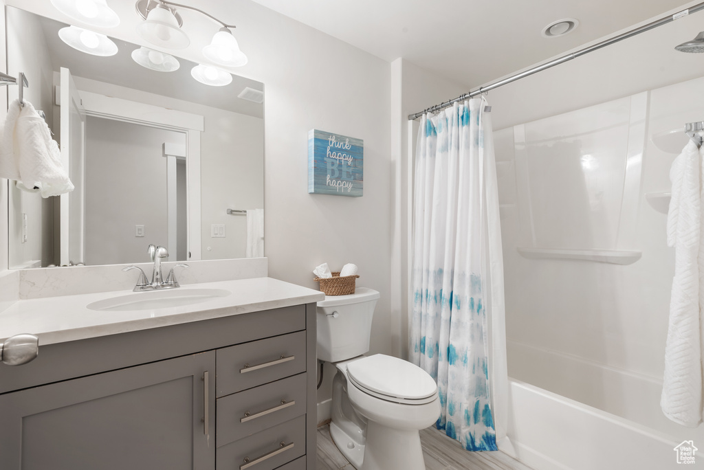 Full bath featuring toilet, vanity, and shower / bath combination with curtain