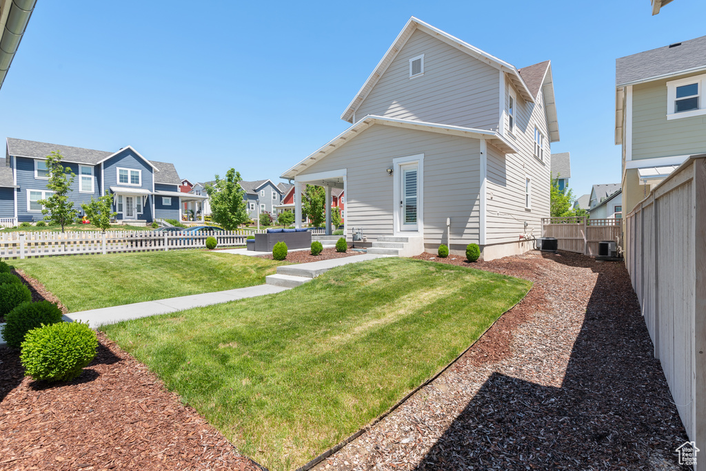Rear view of property with a residential view, entry steps, central AC unit, and a patio