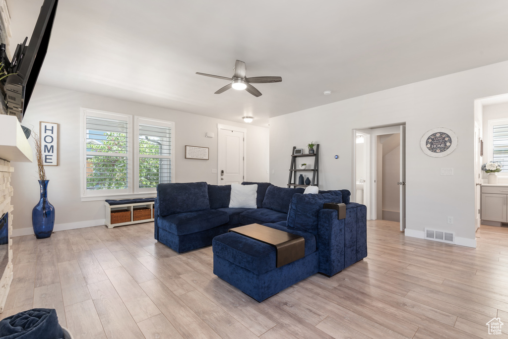 Living area featuring ceiling fan, light wood-style flooring, and baseboards