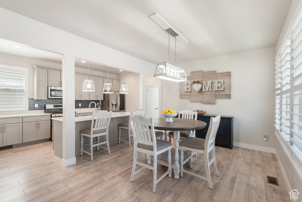 Dining area with light wood-type flooring, plenty of natural light, and recessed lighting