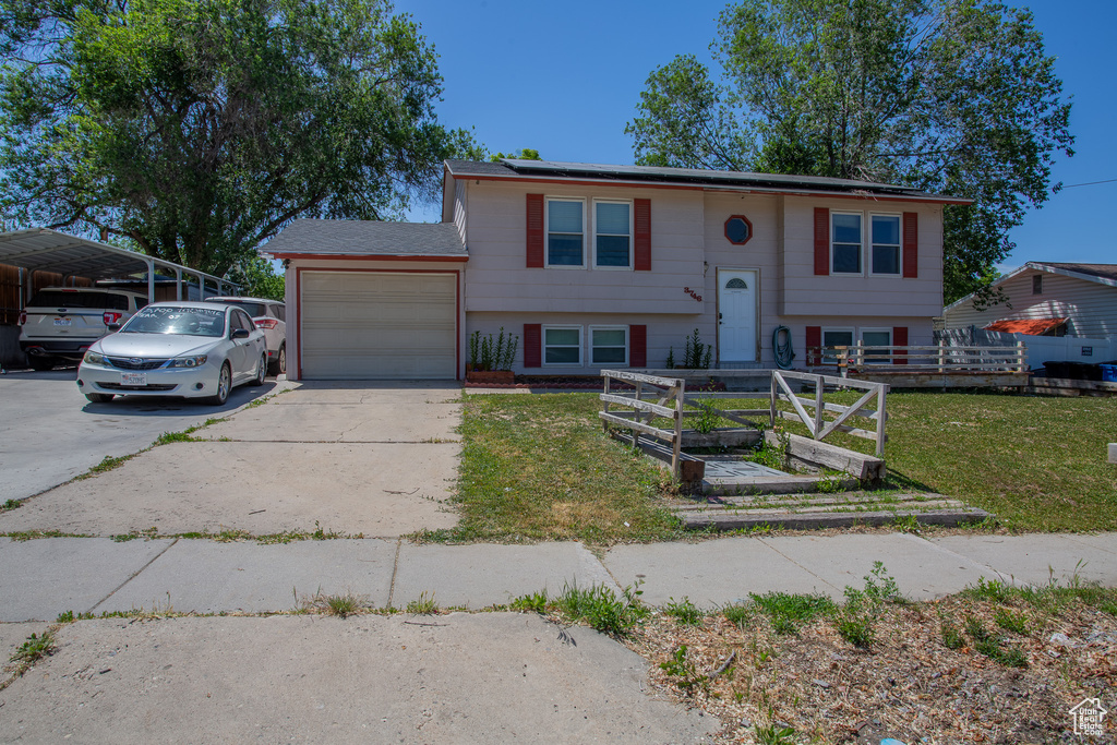 Raised ranch with an attached garage and concrete driveway