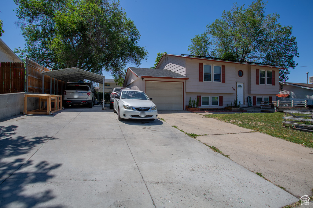 Split foyer home featuring a carport, concrete driveway, and a garage