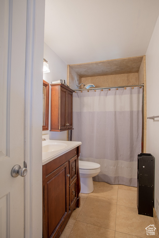 Full bath with vanity, toilet, tile patterned floors, and a shower with shower curtain