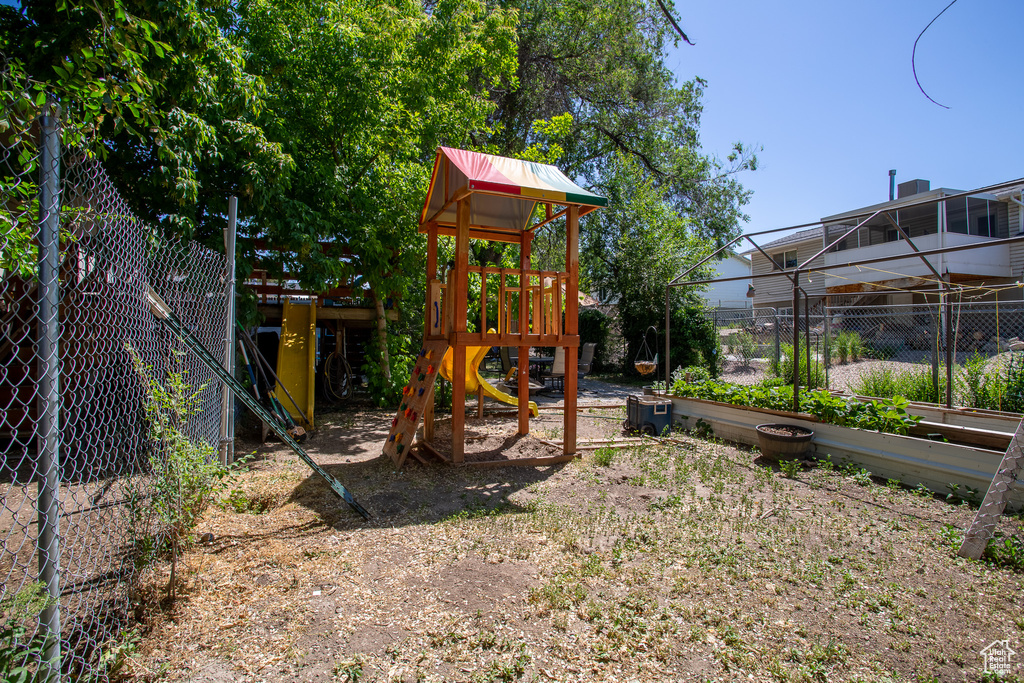 View of jungle gym featuring a garden