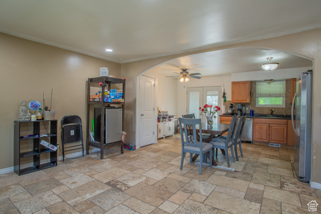 Dining area featuring arched walkways, stone tile flooring, recessed lighting, ceiling fan, and baseboards