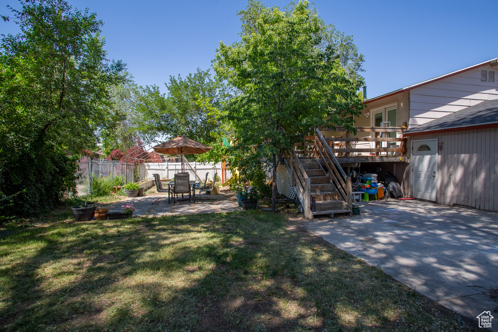 View of yard featuring a patio, a wooden deck, and stairs