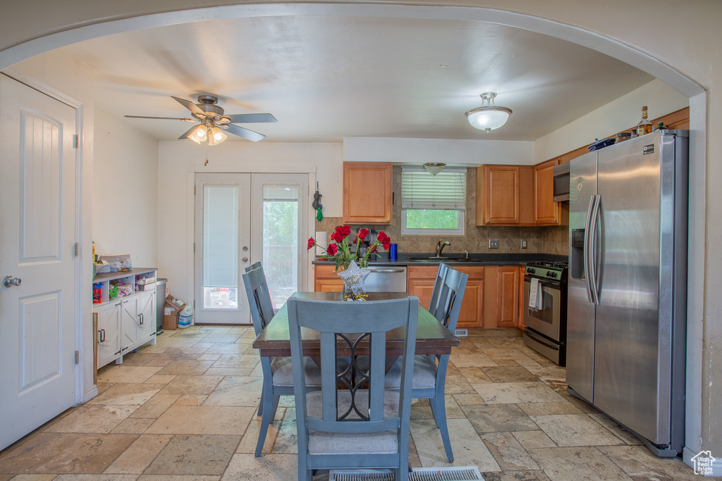 Kitchen featuring stainless steel appliances, stone tile floors, a sink, and tasteful backsplash