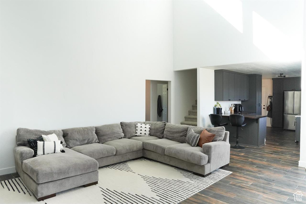 Living area featuring dark wood finished floors, stairs, and baseboards