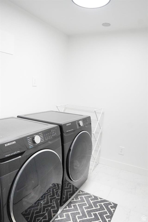 Washroom with separate washer and dryer and baseboards