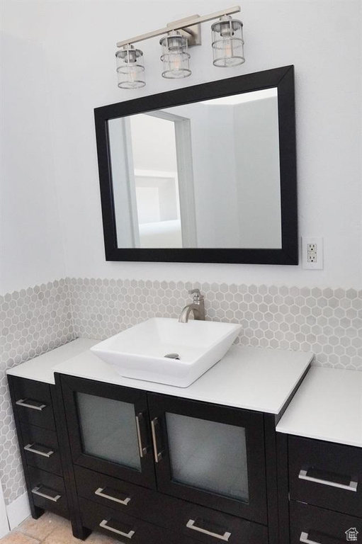 Bathroom with vanity, tile patterned floors, and tasteful backsplash