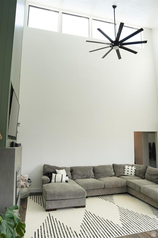 Living area with ceiling fan and a towering ceiling
