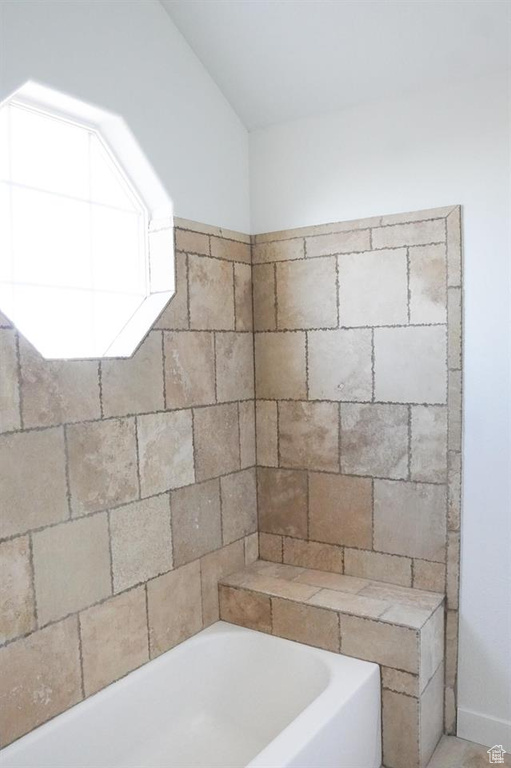 Full bathroom with a bathtub and vaulted ceiling