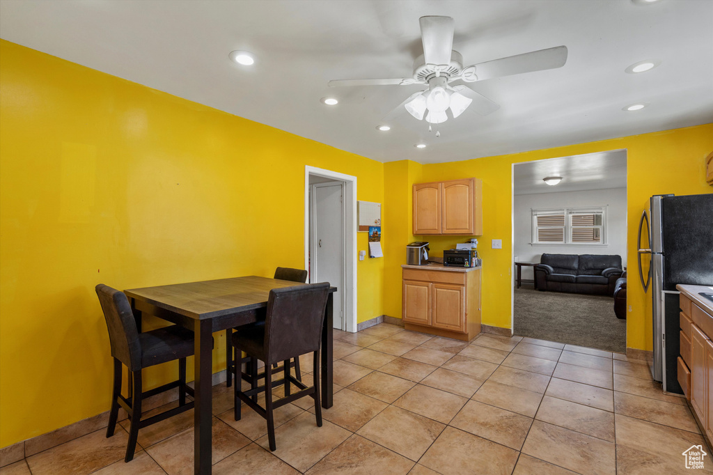 Dining area with a ceiling fan, recessed lighting, light tile patterned flooring, light carpet, and baseboards