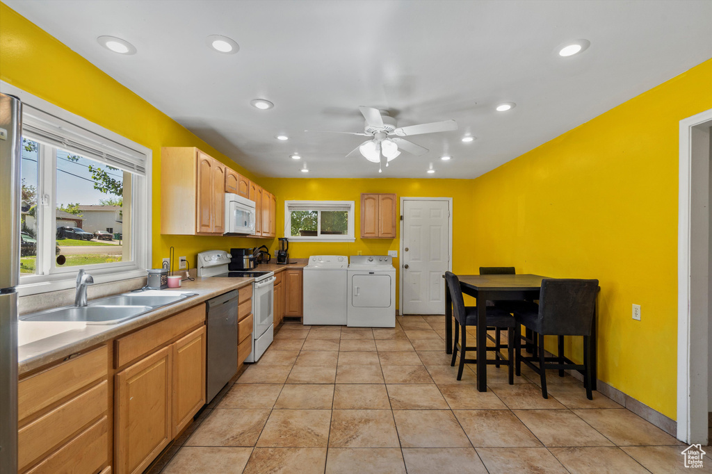 Kitchen with white appliances, washer and dryer, a sink, ceiling fan, and recessed lighting