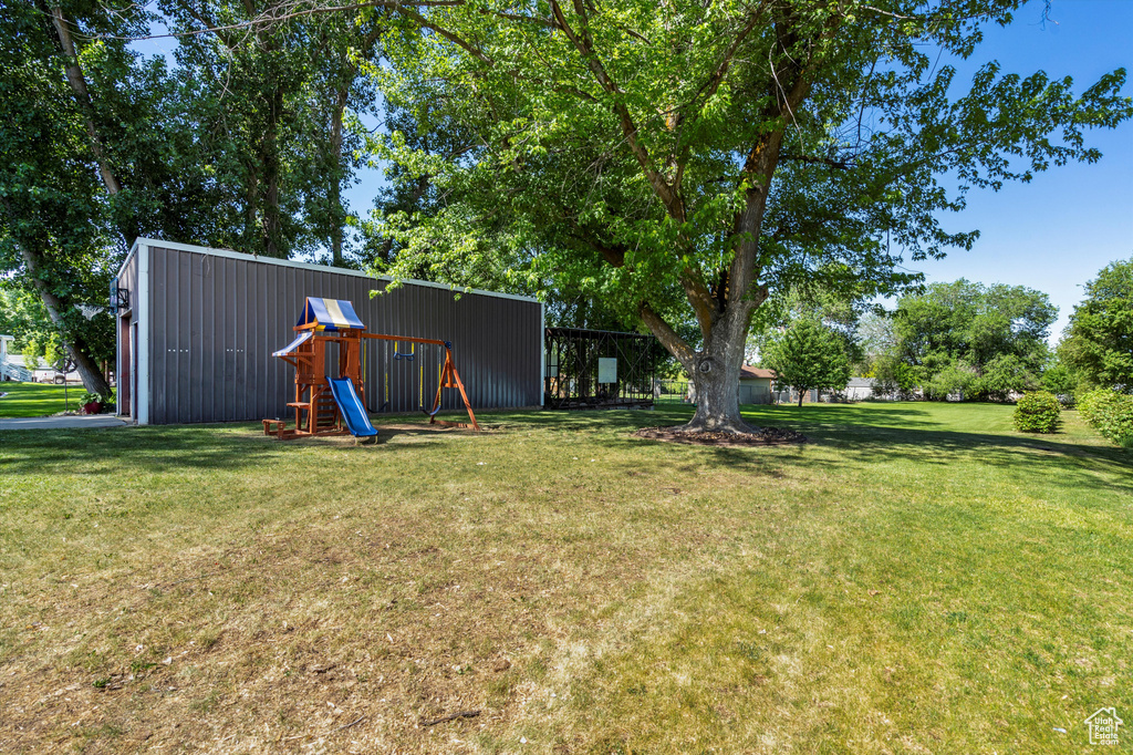 View of green lawn featuring an outbuilding and an outdoor structure