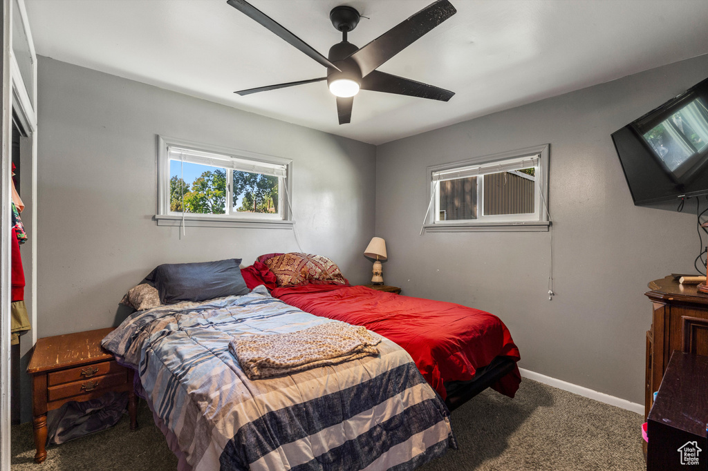 Carpeted bedroom featuring baseboards and ceiling fan