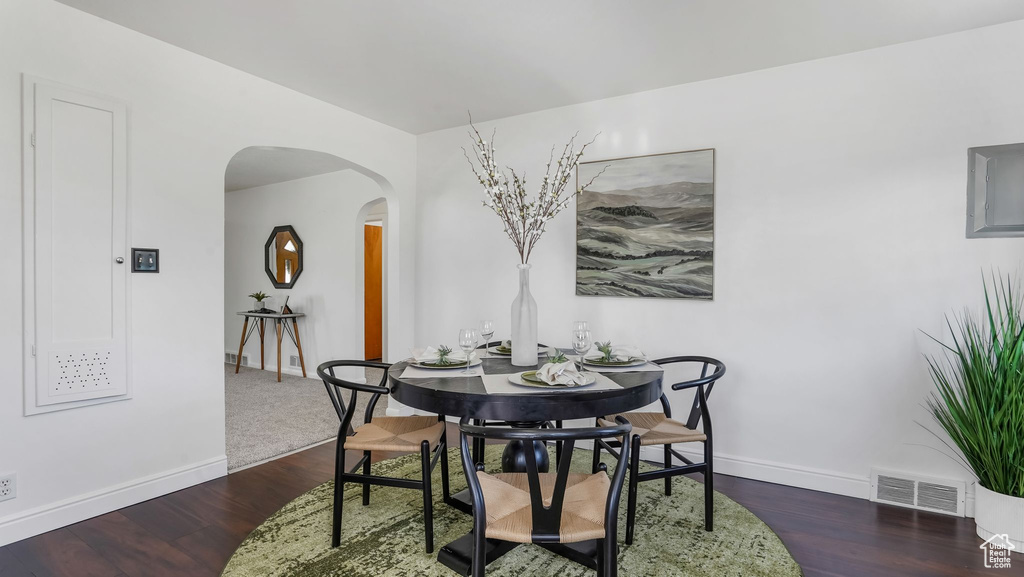 Dining room with arched walkways, baseboards, and wood finished floors
