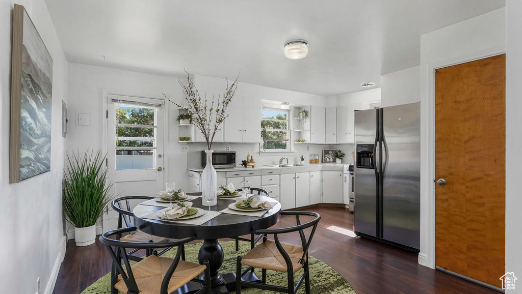 Dining room with dark wood-style floors and baseboards