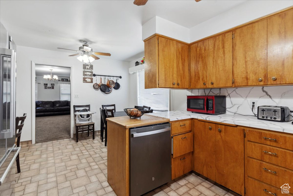 Kitchen with stainless steel dishwasher, a ceiling fan, decorative backsplash, and brown cabinets