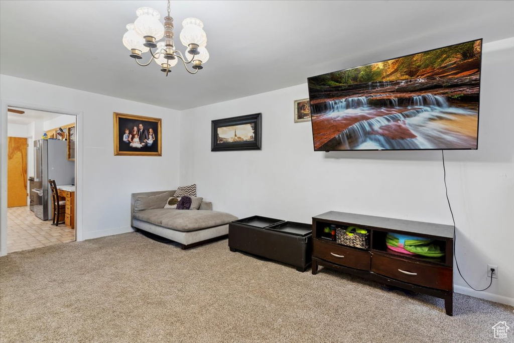 Sitting room with carpet floors, a chandelier, and baseboards