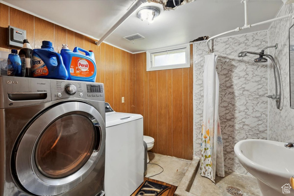 Laundry area featuring washer / clothes dryer and wood walls