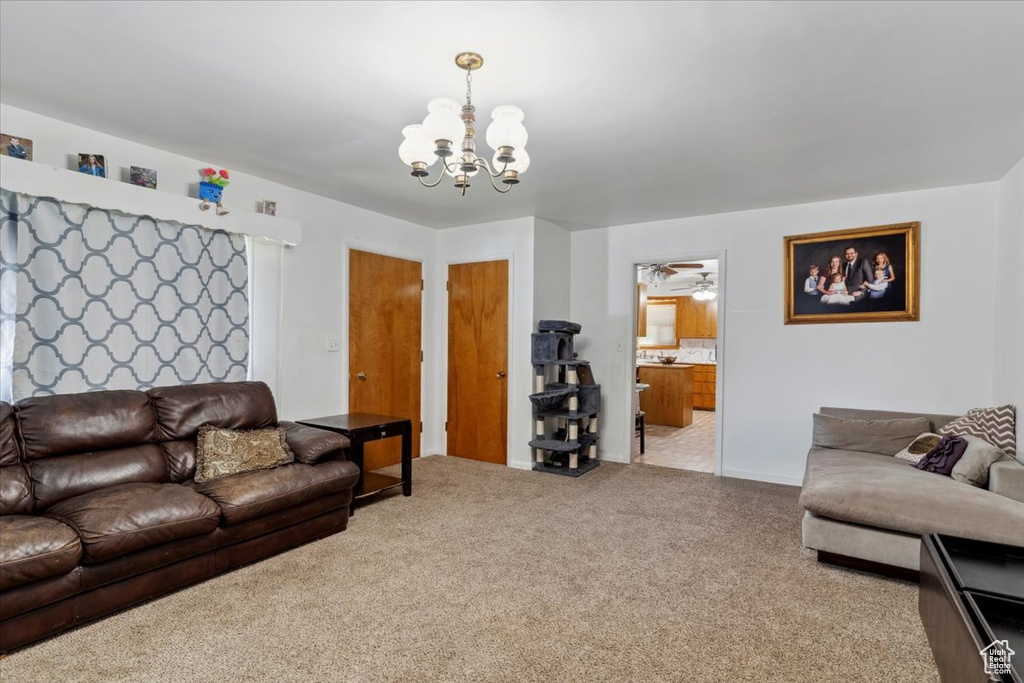 Carpeted living room with a chandelier