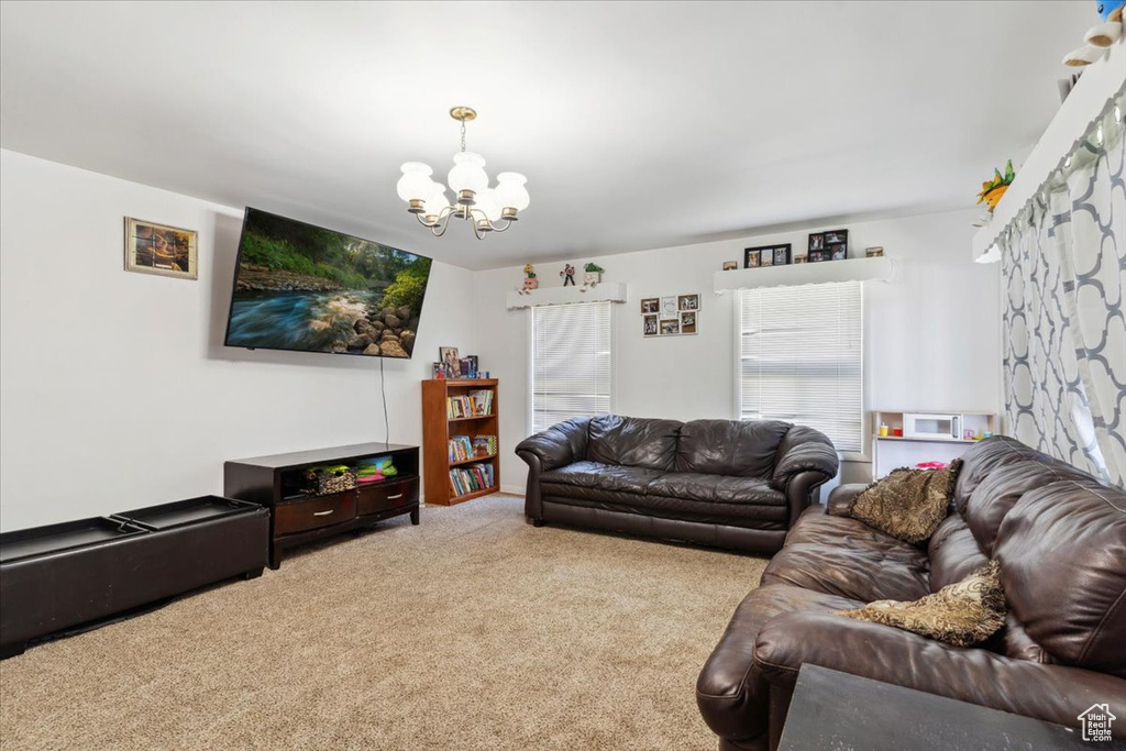 Carpeted living room featuring a chandelier