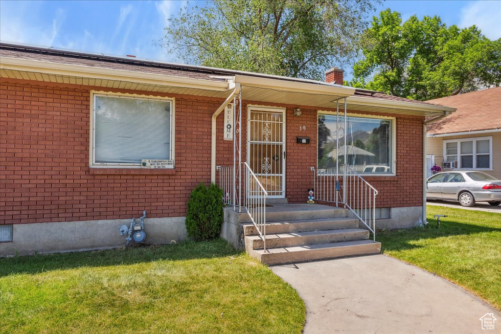 Single story home featuring a front lawn and brick siding