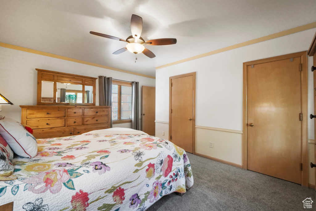 Carpeted bedroom featuring a ceiling fan