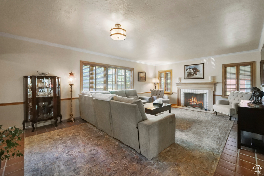 Living room with crown molding, a brick fireplace, and baseboards